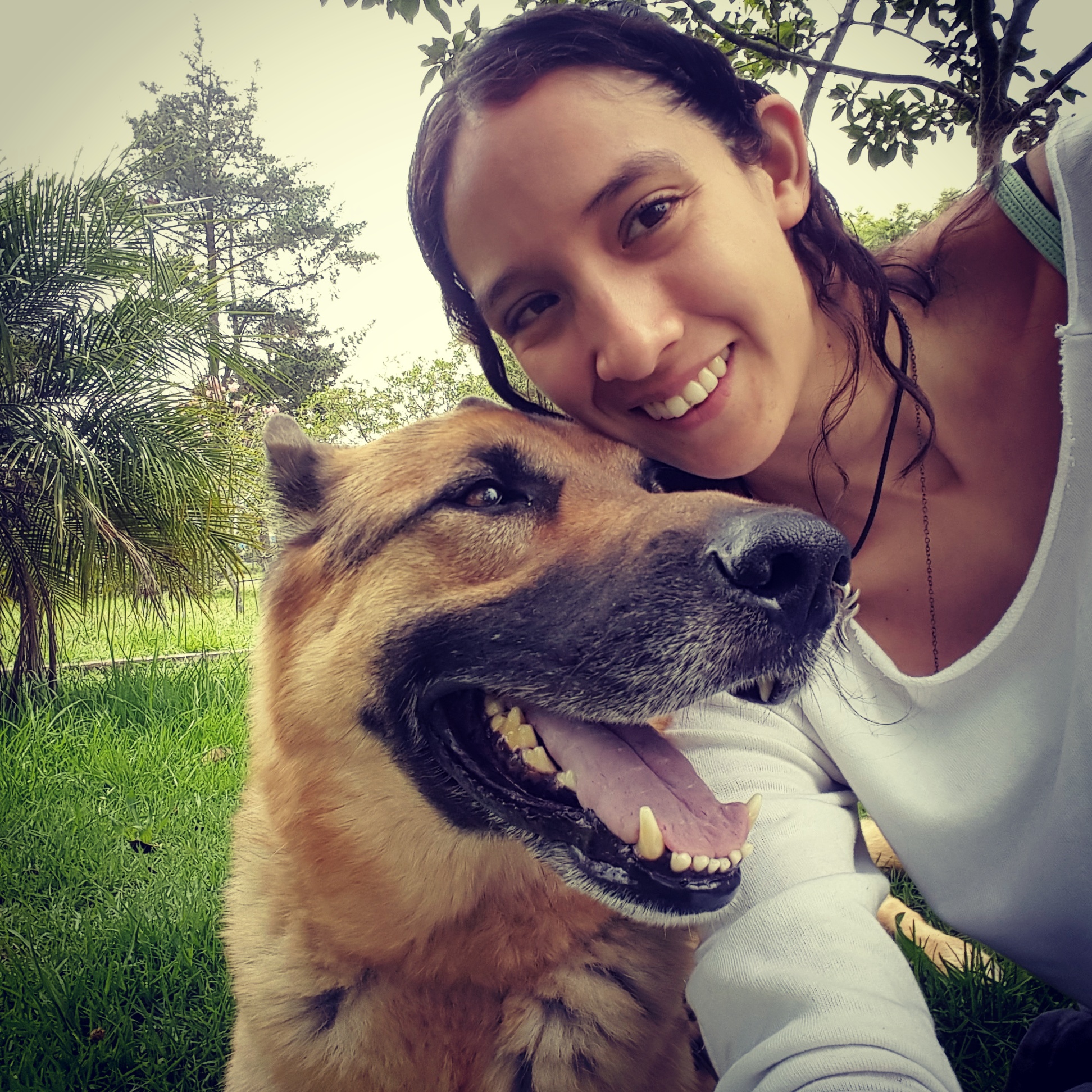 Picture of Izzy Quintana with her dog Coco, a smiling German Shepherd