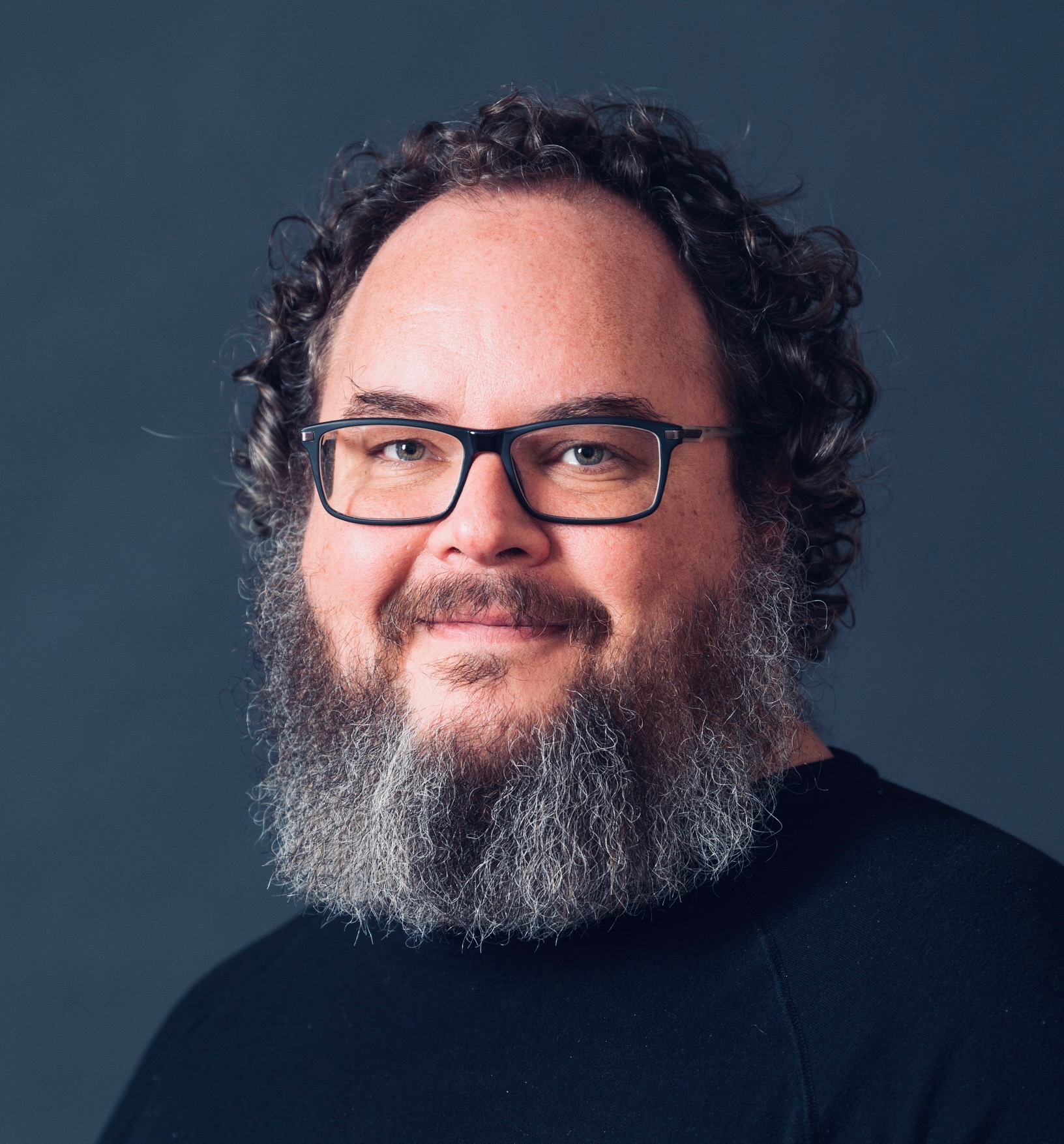 Headshot of Kris Reed on gray background